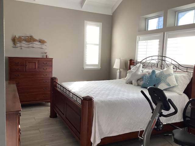 bedroom featuring light wood-type flooring and vaulted ceiling