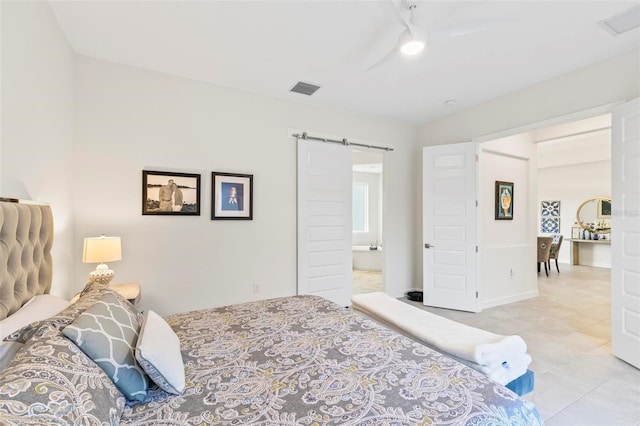 bedroom with a barn door, visible vents, and a ceiling fan