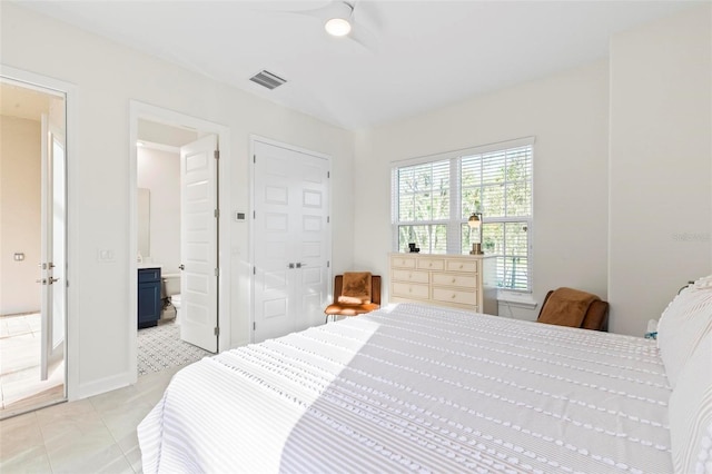 bedroom with light tile patterned floors, a ceiling fan, visible vents, and connected bathroom