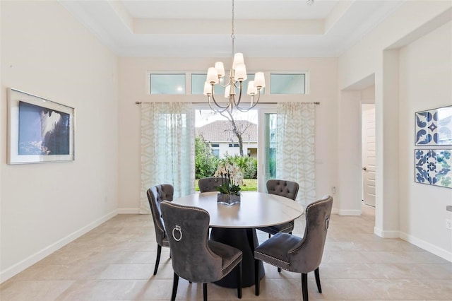 dining area featuring an inviting chandelier, baseboards, and a tray ceiling