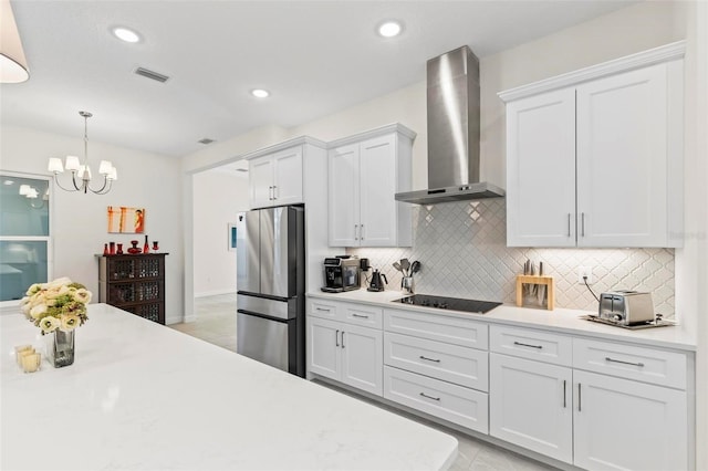 kitchen featuring white cabinets, wall chimney exhaust hood, light countertops, and freestanding refrigerator