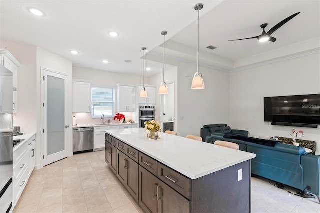 kitchen featuring a sink, light countertops, white cabinets, appliances with stainless steel finishes, and tasteful backsplash