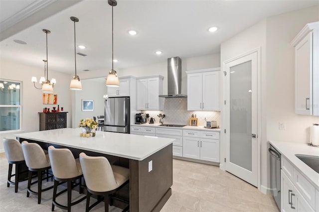 kitchen featuring tasteful backsplash, a center island, a breakfast bar area, stainless steel appliances, and wall chimney exhaust hood