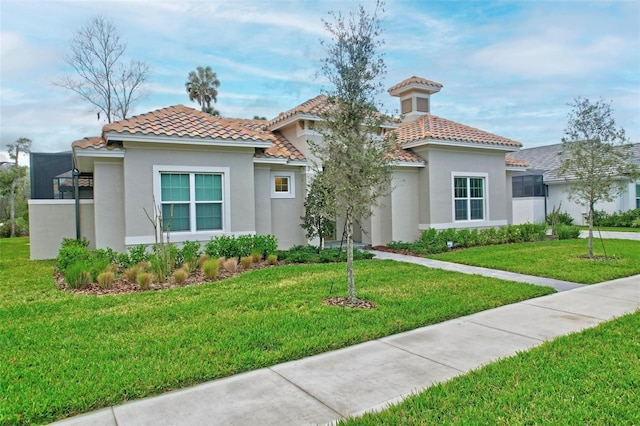 mediterranean / spanish-style house with a front lawn, a tile roof, and stucco siding