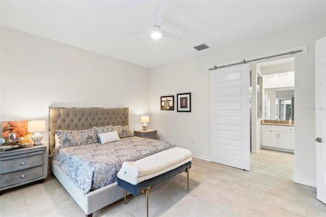 bedroom with visible vents, baseboards, a barn door, a ceiling fan, and a sink