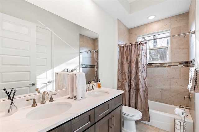 full bathroom with a sink, shower / bath combo with shower curtain, toilet, and double vanity