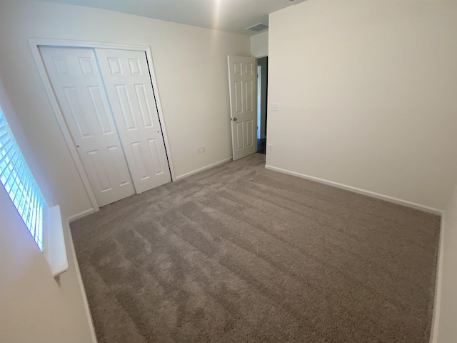 unfurnished bedroom featuring carpet and a closet