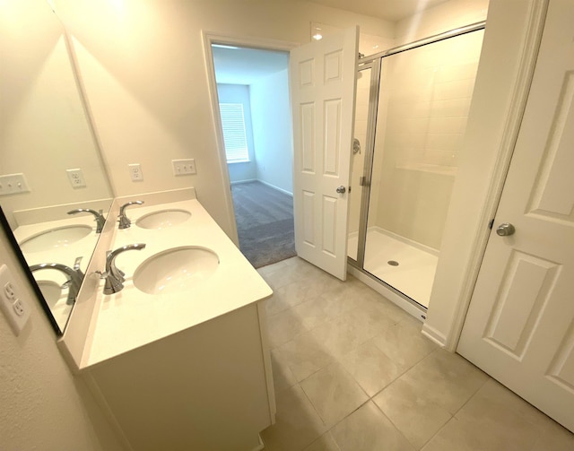 bathroom featuring tile patterned flooring, vanity, and a shower with shower door