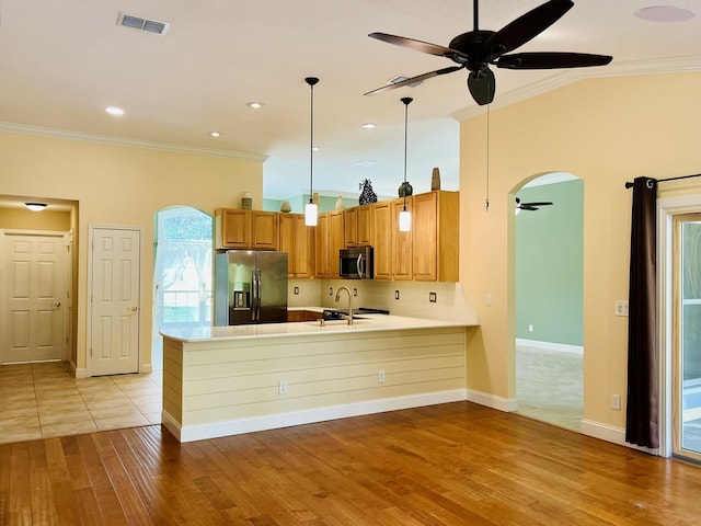 735 E Red House Branch Rd, Saint Augustine, FL 32084 - kitchen with stainless steel appliances, ceiling fan, ornamental molding, a peninsula, and brown cabinetry
