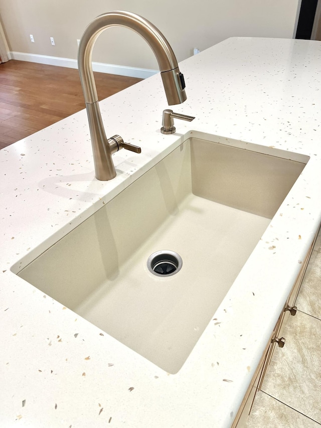 735 E Red House Branch Rd, Saint Augustine, FL 32084 - details featuring light stone countertops, a sink, wood finished floors, and baseboards