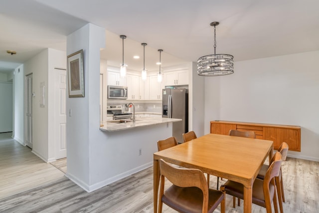 31 Catalonia Ct, Saint Augustine, FL 32086 - dining space with a notable chandelier, baseboards, and light wood-type flooring