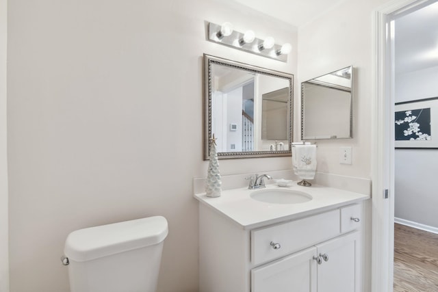 bathroom with vanity, wood-type flooring, and toilet