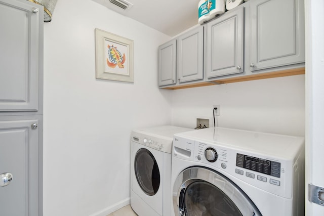 washroom featuring washer and clothes dryer and cabinets