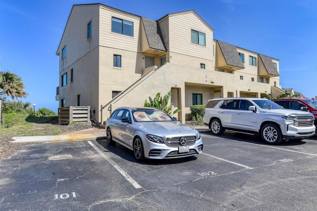 8550 S A1A # 102, Saint Augustine, FL 32080 - exterior space featuring uncovered parking, stucco siding, and stairway