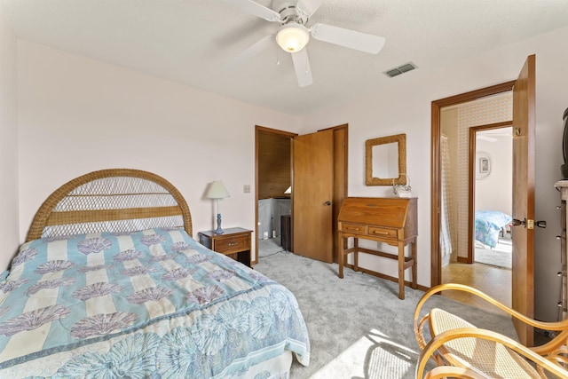 bedroom with visible vents, ceiling fan, and light carpet