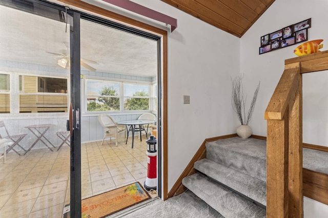 stairs with wooden ceiling, vaulted ceiling, baseboards, and ceiling fan