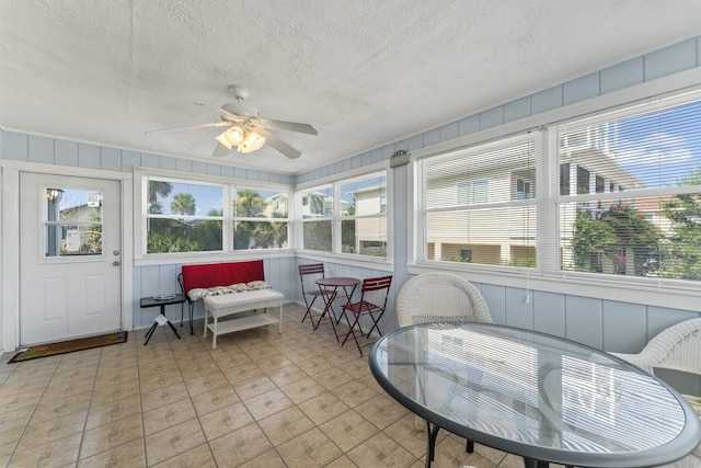 sunroom / solarium featuring a ceiling fan