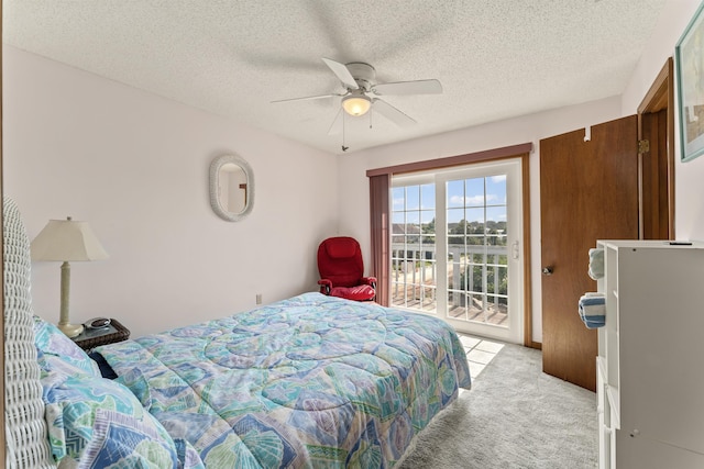 bedroom with light carpet, a textured ceiling, a ceiling fan, and access to exterior