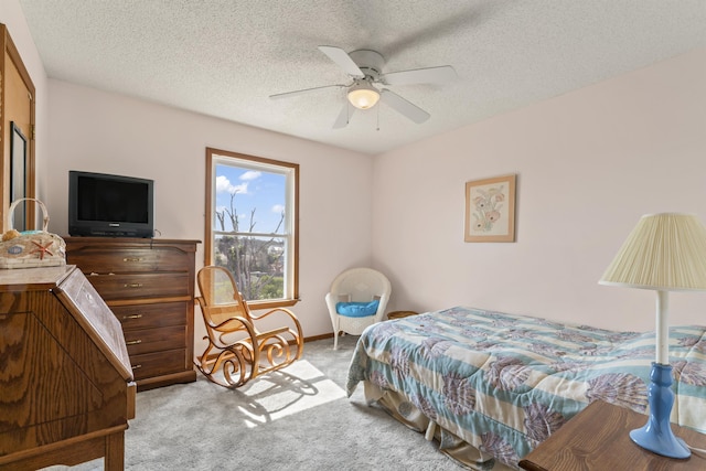 carpeted bedroom with ceiling fan and a textured ceiling