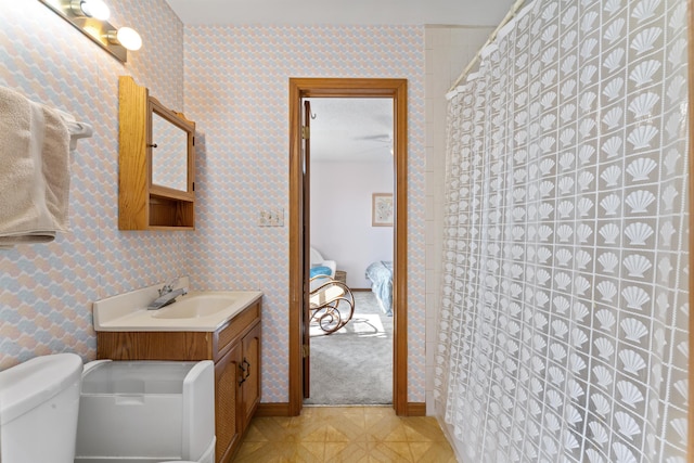 ensuite bathroom with wallpapered walls, tile patterned flooring, ensuite bathroom, and vanity