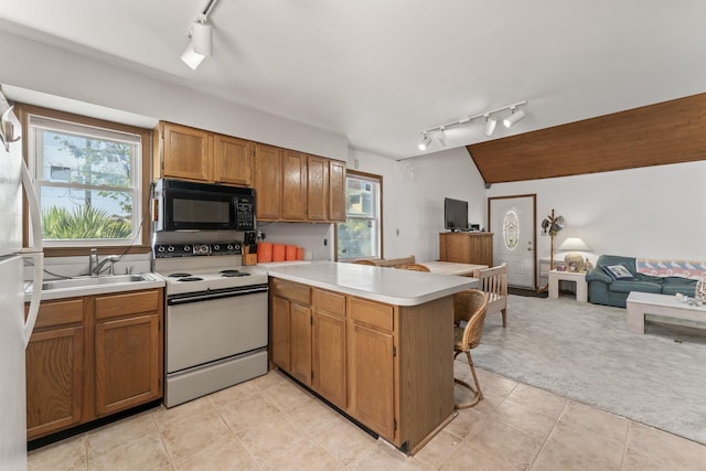 kitchen with white electric stove, open floor plan, a sink, black microwave, and a peninsula