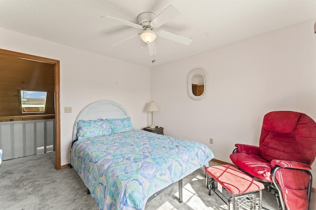 carpeted bedroom featuring a textured ceiling, a ceiling fan, and baseboards