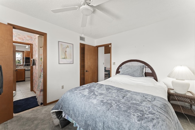 bedroom with light carpet, baseboards, visible vents, ceiling fan, and a textured ceiling