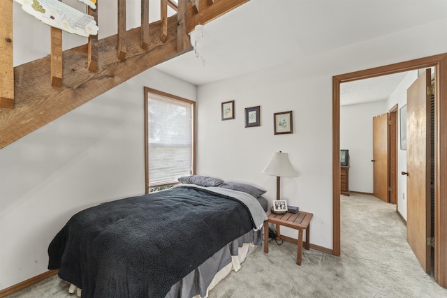 bedroom featuring baseboards and light colored carpet