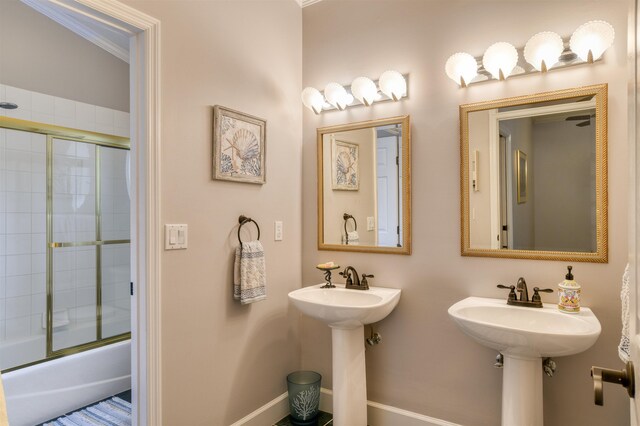 bathroom featuring sink and shower / bath combination with glass door