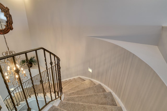 stairs featuring carpet and a chandelier