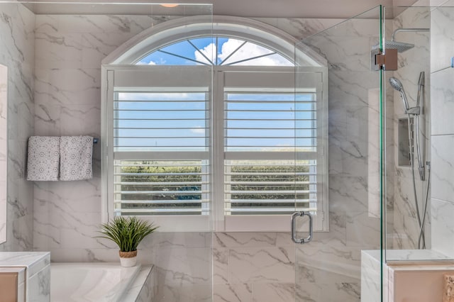 bathroom featuring shower with separate bathtub and a healthy amount of sunlight