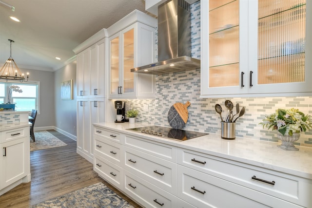 616 Mediterranean Way, Saint Augustine, FL 32080 - kitchen with wall chimney range hood, ornamental molding, black electric cooktop, white cabinetry, and a chandelier