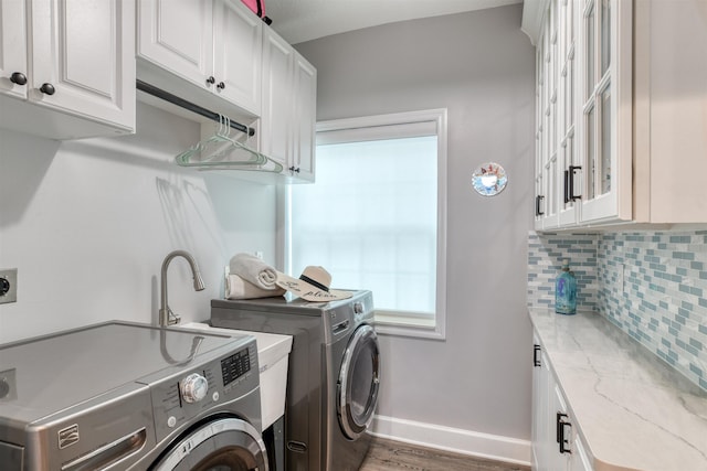 laundry room featuring cabinets, washer and dryer, and dark hardwood / wood-style flooring