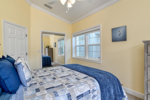 carpeted bedroom featuring ceiling fan, vaulted ceiling, crown molding, and a closet