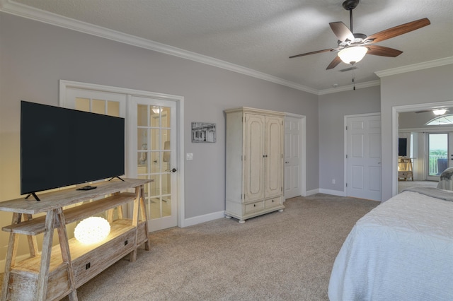 carpeted bedroom featuring ornamental molding, french doors, a textured ceiling, and ceiling fan