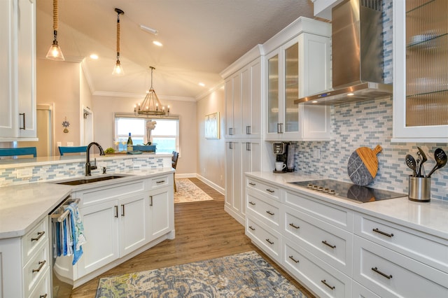 kitchen with white cabinetry, decorative light fixtures, light stone counters, black electric stovetop, and wall chimney range hood