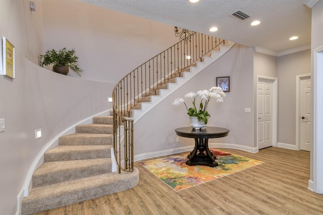 stairs with hardwood / wood-style flooring and a textured ceiling