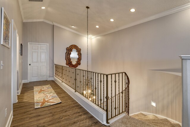 hallway with ornamental molding, dark wood-type flooring, and vaulted ceiling