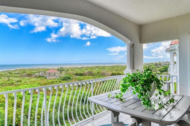 balcony featuring a water view and a beach view