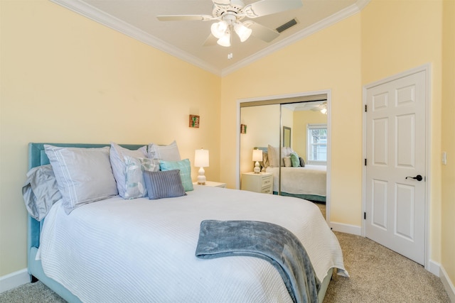 carpeted bedroom with a closet, lofted ceiling, crown molding, and ceiling fan