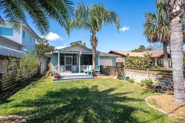 back of property with a yard, a fenced backyard, and a garage