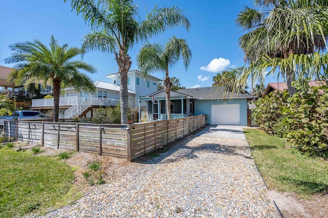 view of front facade featuring stucco siding, concrete driveway, a garage, and fence