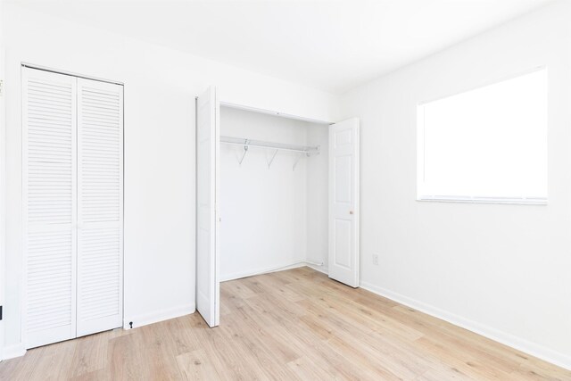 unfurnished bedroom featuring two closets and light hardwood / wood-style flooring