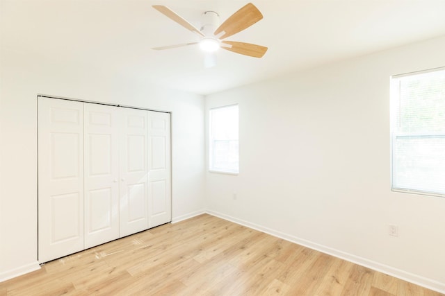 unfurnished bedroom with ceiling fan, light wood-type flooring, and a closet