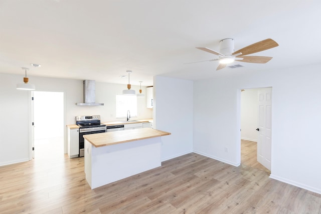 kitchen with wall chimney exhaust hood, sink, pendant lighting, stainless steel appliances, and white cabinets