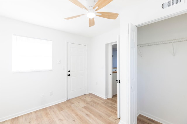 unfurnished bedroom with ceiling fan, a closet, and light wood-type flooring