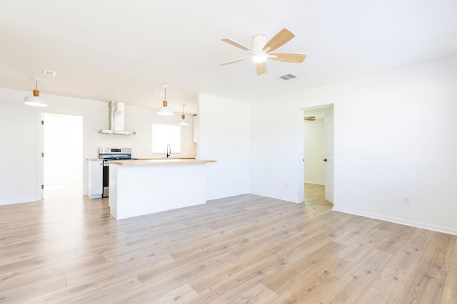 unfurnished living room with ceiling fan and light wood-type flooring