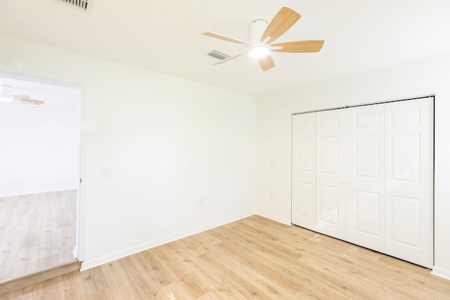 unfurnished bedroom featuring ceiling fan, light wood-type flooring, and a closet