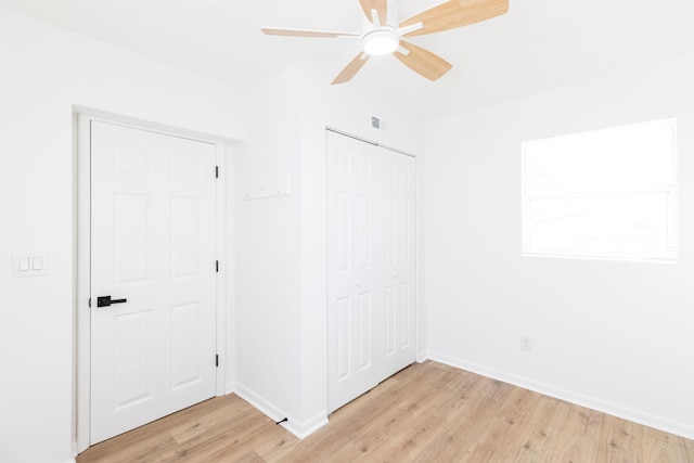 unfurnished bedroom with ceiling fan, a closet, and light wood-type flooring