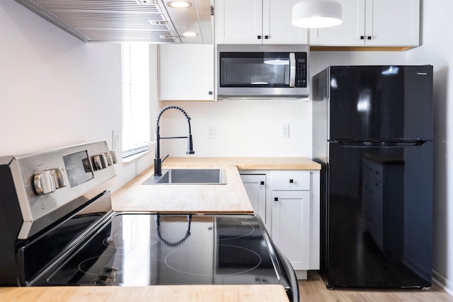 kitchen featuring sink, white cabinetry, butcher block counters, stainless steel appliances, and exhaust hood